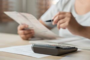 Guide to remortgaging - woman using calculator with paperwork